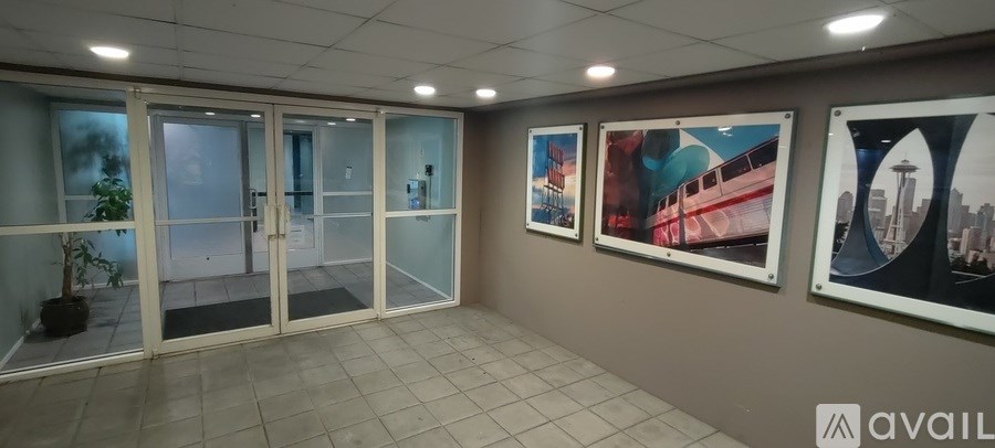 A hallway with glass doors and pictures on the wall.