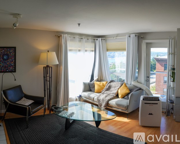 A living room with a sofa, chair, and a table.