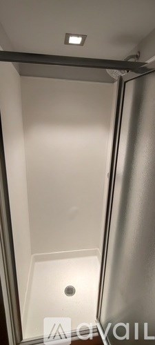 A small, empty room with a drain in the middle of the floor.