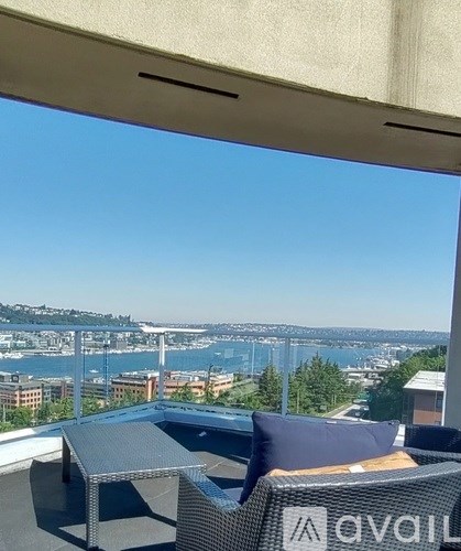 A patio with a table and chairs overlooking a cityscape.