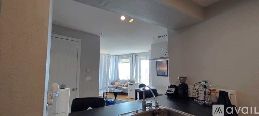 A kitchen with a black countertop and a dining table with chairs.
