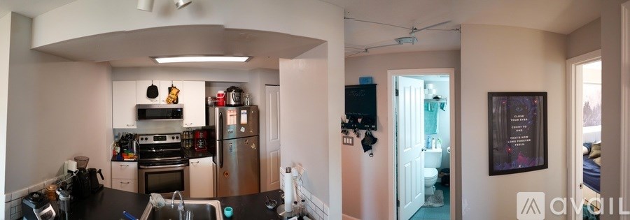 A kitchen with a refrigerator, oven, and sink.