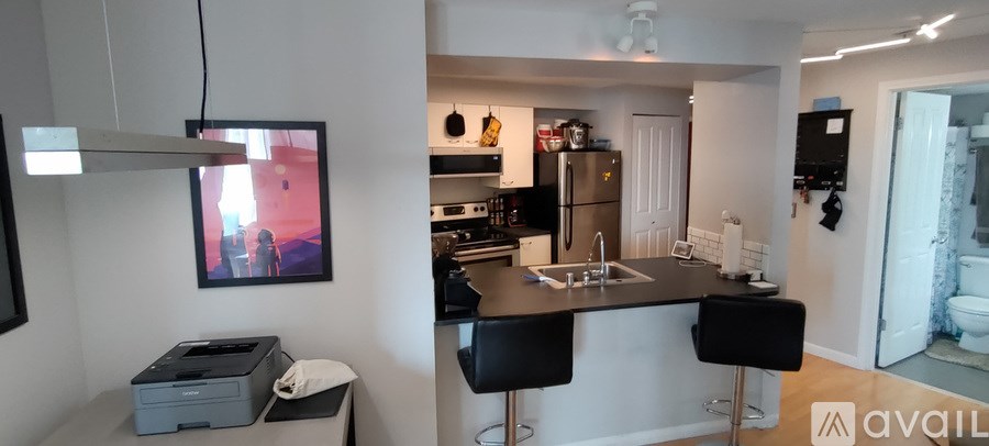 A kitchen with a black countertop and a fridge.