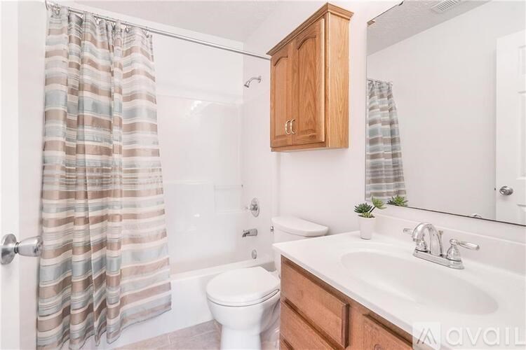 A bathroom with a toilet, sink, and shower curtain.