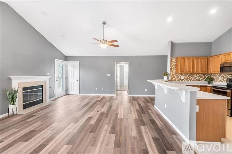 A spacious living room with a fireplace and hardwood floors.