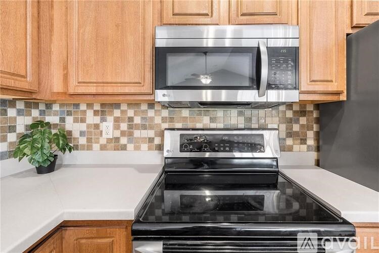 A black stove top oven in a kitchen with wooden cabinets and a tiled backsplash.