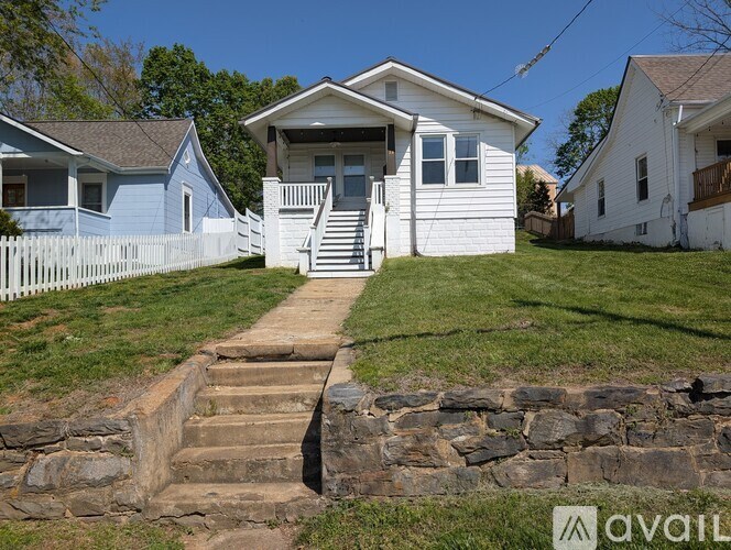 A white house with a stone staircase leading to the front door.