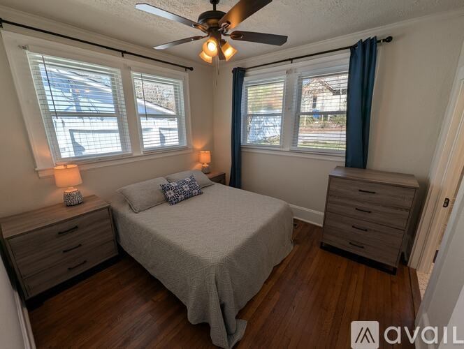 A bedroom with a bed, dresser, and ceiling fan.