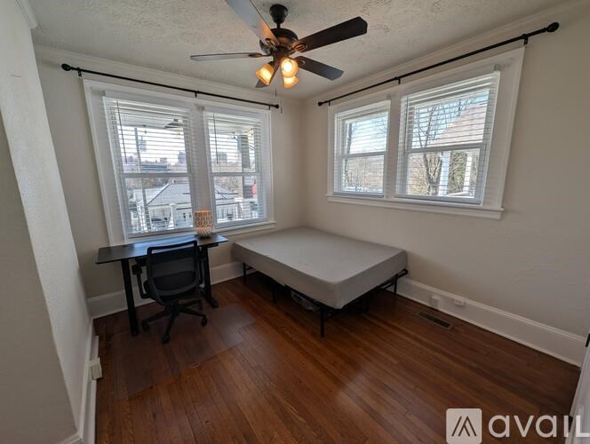 A room with a ceiling fan and a window seat.