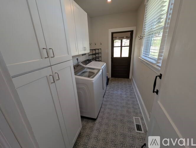 A small kitchen with white cabinets and a washer and dryer.