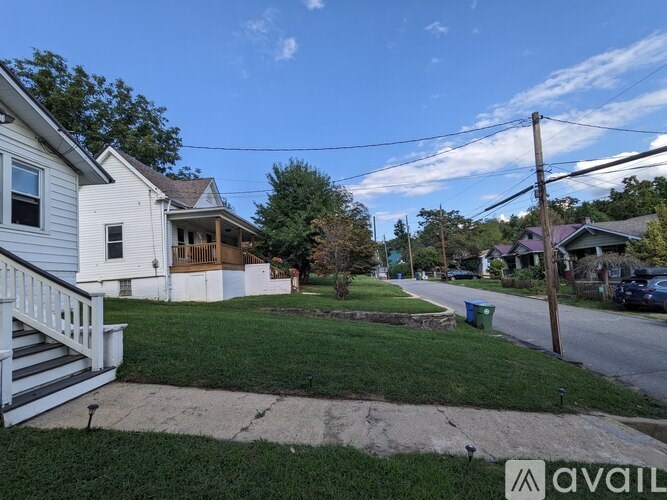 A residential street with houses on both sides and a clear blue sky.