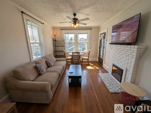 A living room with a fireplace and a television mounted on the wall.