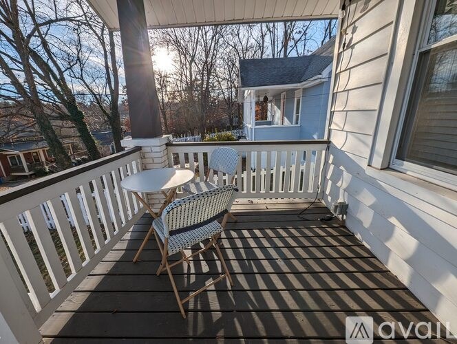 A wooden deck with a chair and table on it.
