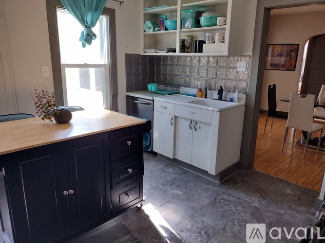 A kitchen with black cabinets and a wooden countertop.