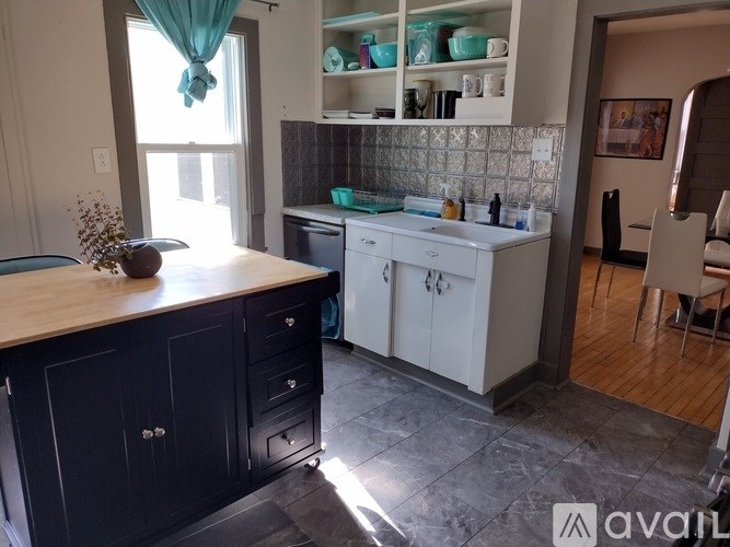 A kitchen with black cabinets and a wooden countertop.