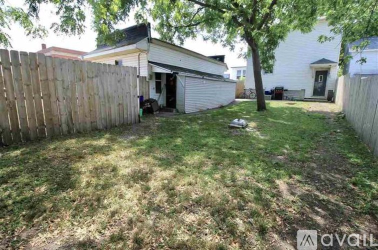A backyard with a fence and a tree.