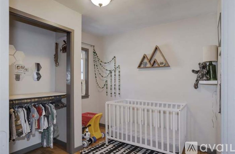 A baby's room with a white crib and a black and white striped rug.