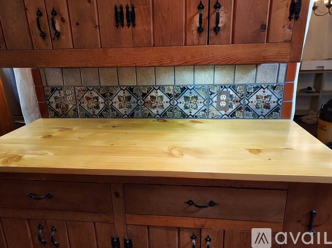 A wooden table with drawers and cabinets above it.