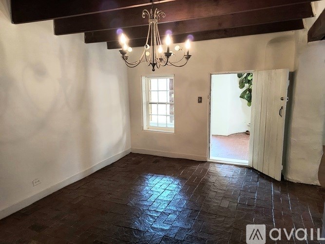 A room with a chandelier and a window.