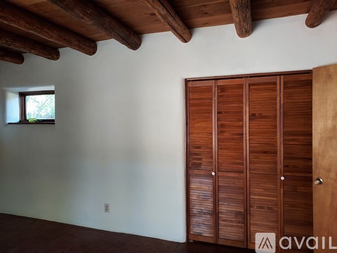 A room with a wooden ceiling and a wooden wardrobe.