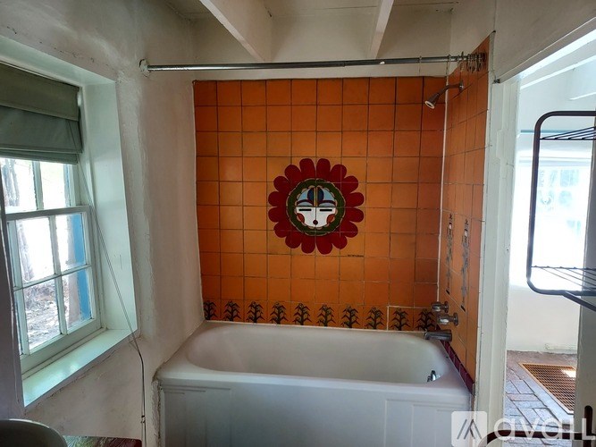 A bathroom with orange tiles and a white bathtub.