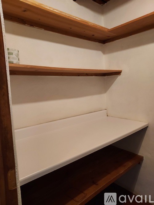 A white shelf with a wooden frame and three shelves.