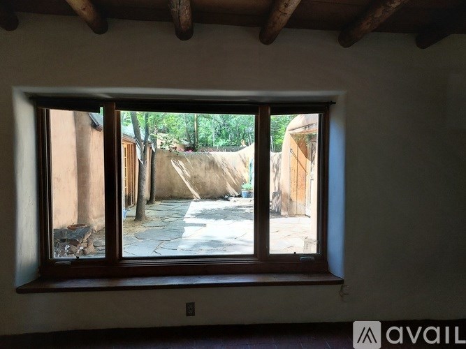 A window with a view of a courtyard and trees.