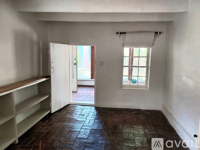 A room with a window and a door leading to another room.