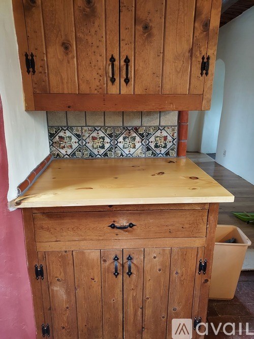 A wooden cabinet with a counter on top is in a room.
