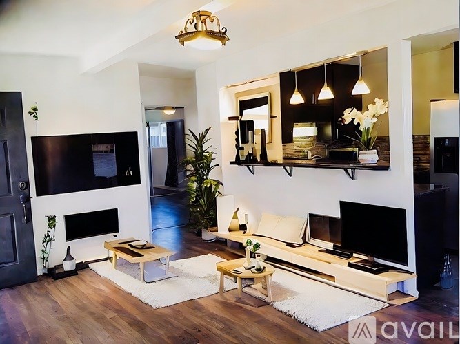 A living room with a fireplace and a tv on the wall.