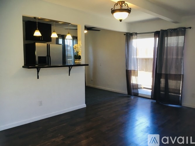 A room with a mirror and a shelf with three lights hanging above it.