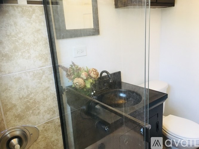 A modern bathroom with a glass shower door and a toilet.