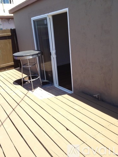 A table and chair set is on a wooden deck.