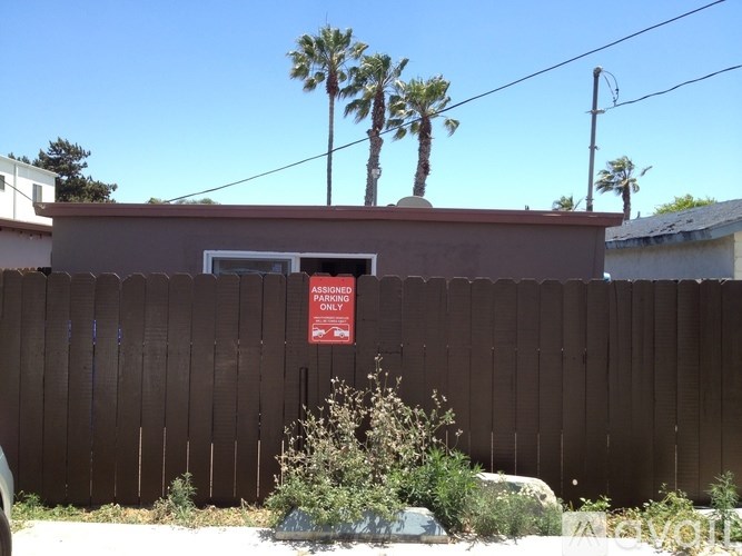 A brown fence with a sign that says "ASSIGNED PARKING" on it.