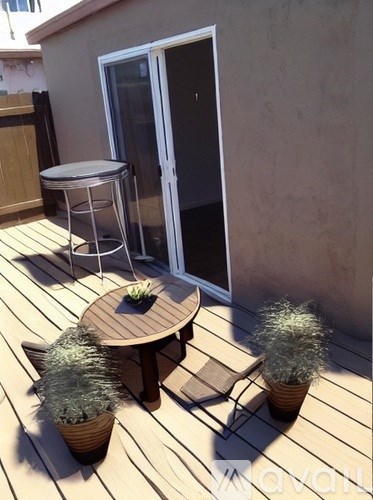 A wooden deck with a table, chairs and plants.