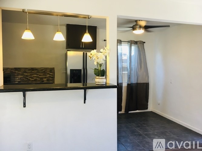 A room with a black countertop and a mirror above it.