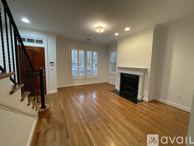 A living room with a fireplace and a staircase.