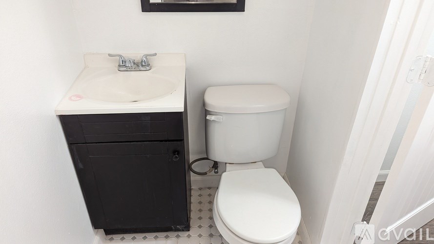 A white toilet sits next to a sink in a small bathroom.