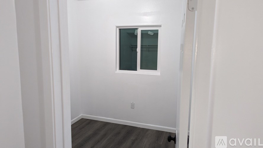 A room with a window and wooden flooring.