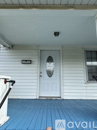 A white house with a blue floor and a white door.
