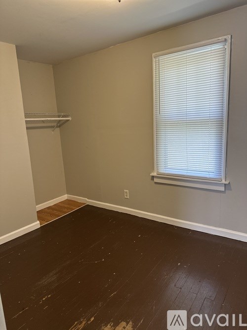 A room with a window and wooden floor.