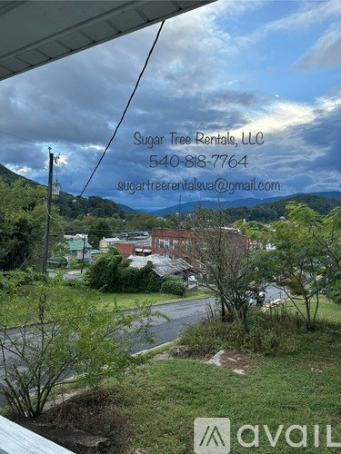 A view from a window overlooking a residential area with houses and trees.
