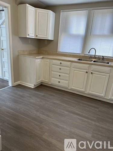A kitchen with white cabinets and a sink.