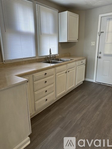 A kitchen with white cabinets and a sink.