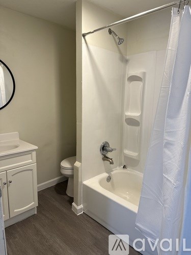 A white bathroom with a toilet, sink, and bathtub.