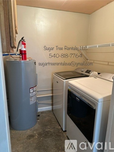 A small kitchen with a grey fridge, a white oven and a white dishwasher.