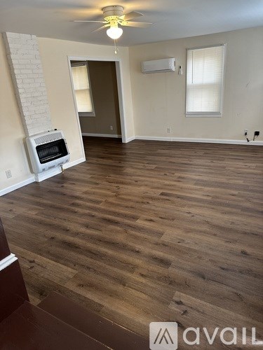 A room with wooden floors and a white ceiling fan.