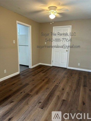 A room with wooden flooring and a ceiling fan.