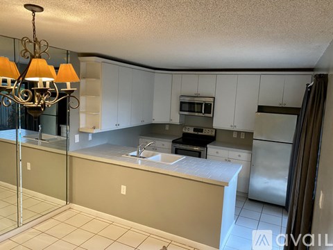 A kitchen with white cabinets and a beige island.