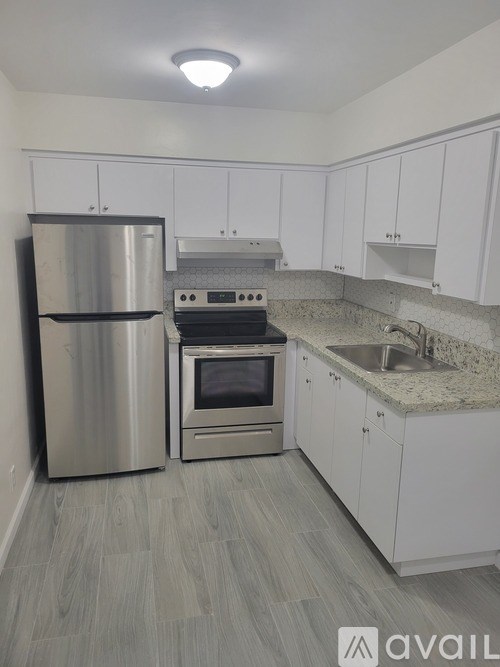 A kitchen with a stainless steel refrigerator, oven, and cabinets.